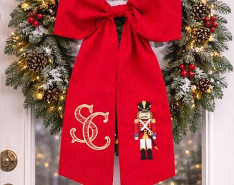 Lazo navideño con inicial bordada personalizada, elegante producto de tela roja, estilo clásico y tradicional para las fiestas, regalo de recuerdo festivo.