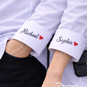 May include: White dress shirts with personalized cuff details. One cuff reads "Michael" with a red heart, the other reads "Sophia" with a red heart. The ChaptersThreads logo is visible at the bottom.