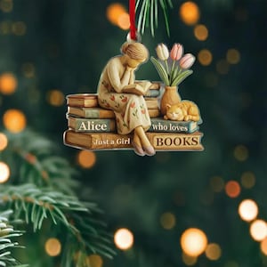 May include: A Christmas ornament featuring a woman reading a book, sitting on a stack of books. The ornament includes a sleeping cat, a vase of tulips, and the text "Alice Just a Girl who loves BOOKS."