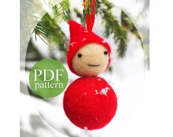 May include: A handmade Christmas ornament featuring a red felt gnome with a round body and pointed hat. The gnome has a tan face with stitched features and is hanging from a red ribbon. The text "PDF pattern" is on a green circle.