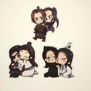 May include: Set of four chibi-style stickers featuring couples in various poses. The stickers depict characters with dark hair and outfits in shades of brown, black, and white. The stickers have a white border.