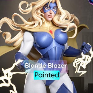 May include: A painted figurine of a blonde superheroine, wearing a blue and white costume with a gold cape. The figure has a mask and is holding a stylized lightning bolt. The text "Blonde Blazer" and "Painted" are visible.