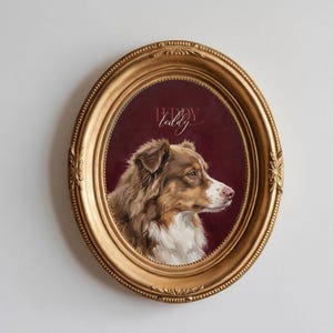 May include: Oval, gold-framed portrait of a dog with brown and white fur, set against a burgundy background. The dog is painted in profile, with the name "Teddy" in cursive script above. The frame has ornate detailing.