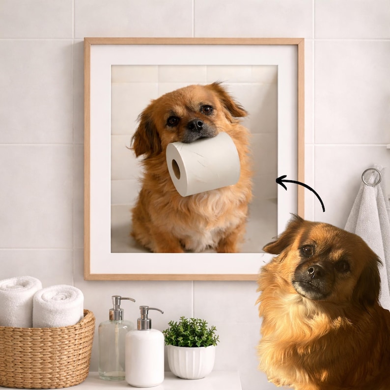 May include: A framed print featuring a small, brown dog holding a roll of white toilet paper in its mouth. The dog is inside a bathroom setting. The frame is light brown. The image is a humorous depiction of a pet.