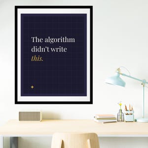 May include: Framed art print with a navy blue background and a grid pattern. The text reads "The algorithm didn't write this." A gold star is in the lower left corner. The print is in a black frame.