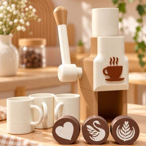 Puede incluir: Una cafetera de juguete de madera en beige y blanco con palanca manual, tres tazas blancas pequeñas y tres discos redondos marrones con diseños de arte latte en blanco de un corazón, un cisne y un patrón de hoja, con un icono de taza de café marrón.