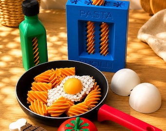 Un set di gioco di ruolo di cucina stampato in 3D con una scatola di pasta, una padella, un uovo, un pomodoro e una bottiglia di salsa. Questo giocattolo da cucina per bambini
