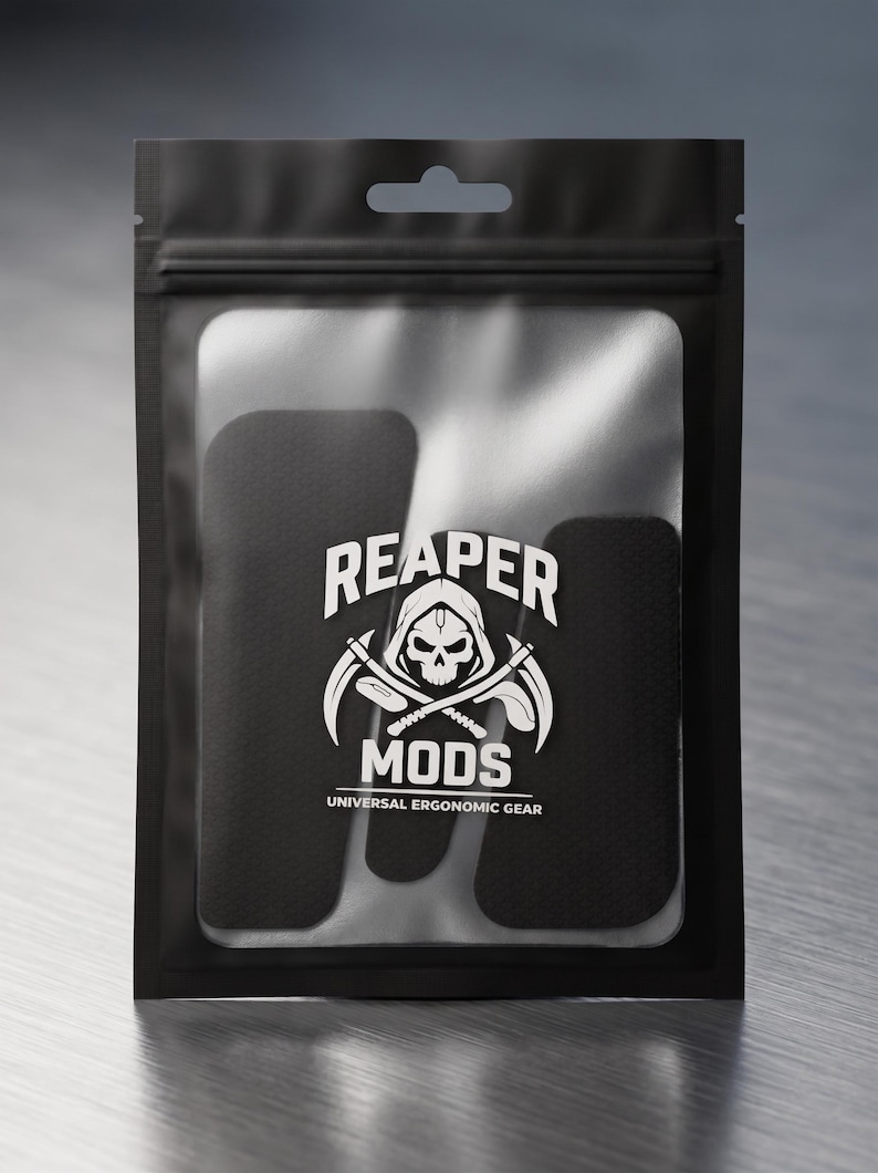 May include: A black resealable plastic pouch containing black adhesive grip tape pieces. The front of the pouch features a white logo with a skull wearing a hood, crossed scythes, and the text REAPER MODS UNIVERSAL ERGONOMIC GEAR printed in white.