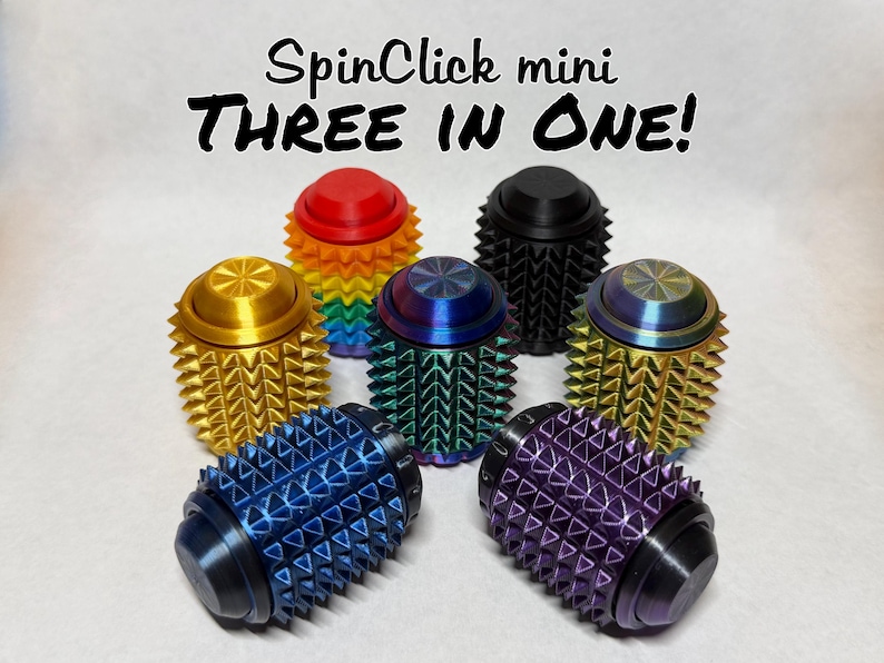 May include: A collection of seven SpinClick mini fidget toys, each featuring a cylindrical body with a textured, spiked surface. The items are displayed in various colors including red, black, gold, blue, purple, and iridescent finishes. Text reads: SpinClick mini THREE IN ONE!