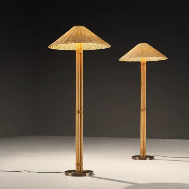 May include: Two bamboo floor lamps with conical woven shades. The lamps have a natural wood finish and a round base. The shades are lit from within, casting a warm glow. The lamps are of different heights.