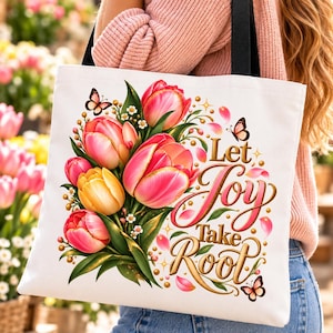 May include: A white tote bag featuring a colorful bouquet of pink and yellow tulips, green leaves, and small butterflies. The text Let Joy Take Root is printed in a decorative gold and pink script font, accented with small golden sparkles.