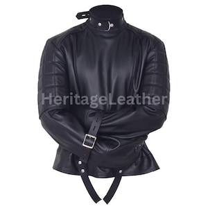 Könnte beinhalten: Schwarze Lederjacke mit hohem Kragen und gesteppten Schulterdetails. Die Jacke hat Riemen mit Metallschnallen und der Text "HeritageLeather" ist sichtbar.