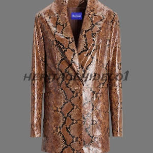 Pode incluir: Um blazer castanho com padrão de pele de cobra, com lapela entalhada e fecho de um botão. O casaco tem mangas compridas e um corte sob medida. A palavra "Heritage" está numa etiqueta azul no interior.