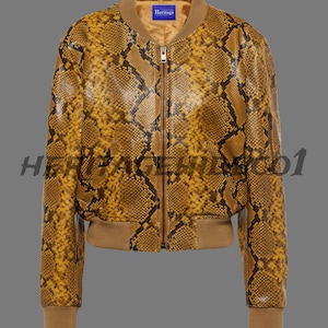 Peut inclure: Veste de bombardier à motif peau de serpent jaune et marron, avec col, poignets et ourlet côtelés marron. Fermeture éclair et petite étiquette bleue "Heritage".