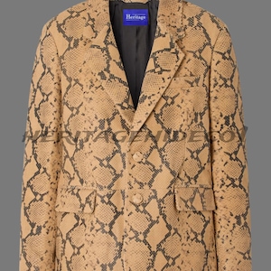 Op de afbeelding: Tan en zwarte blazer met slangenpatroon, met twee voorzakken en twee knopen. De blazer heeft een revers met inkeping en een donkere voering. Het label aan de binnenkant luidt "Heritage".