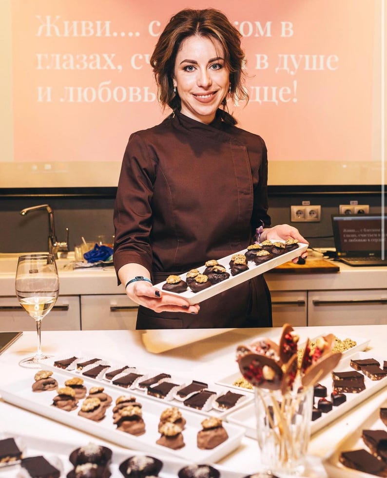Puede incluir: Una taza de cer&aacute;mica blanca con un asa negra y el texto "But First, Coffee" en negro en negrita. La taza est&aacute; sobre una superficie blanca. La taza mide aproximadamente 10 cm de alto.