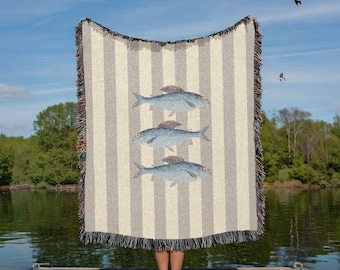 Manta tejida 100% algodón con estampado de sardinas a rayas, ideal para casas de playa y decoración costera. Color gris.