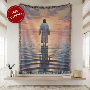 May include: Woven tapestry throw blanket depicting a religious scene of a figure on water at sunset. The artwork uses blue, orange, and yellow hues, with a fringed border. A red circle with "FREE SHIPPING" is in the upper left corner.