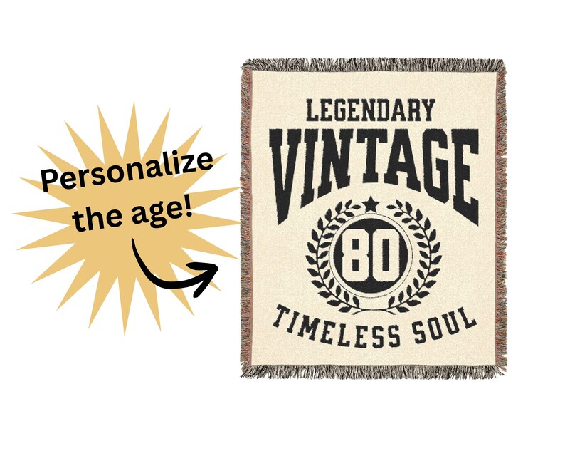 May include: Cream-colored throw blanket with black text that reads "LEGENDARY VINTAGE" above a circular design with the number "80" and the words "TIMELESS SOUL". The blanket has a fringed edge. A yellow starburst graphic with the words "Personalize the age!" is on the left.