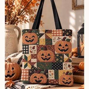 May include: A quilted tote bag featuring a patchwork design of orange jack-o'-lanterns, autumn leaves, and geometric patterns in shades of orange, green, black, and cream. The bag has two black fabric handles and a square, structured silhouette.