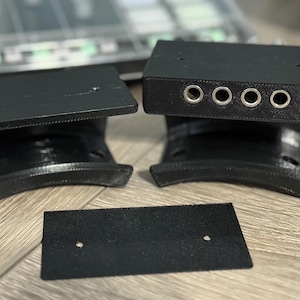 May include: A set of black, 3D-printed electronic components. The set includes two curved base pieces, two rectangular top pieces, and a small rectangular piece. One top piece has four circular openings.