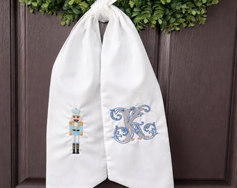 Faja de corona navideña bordada, monograma personalizado, lazo para puerta con diseño de cascanueces