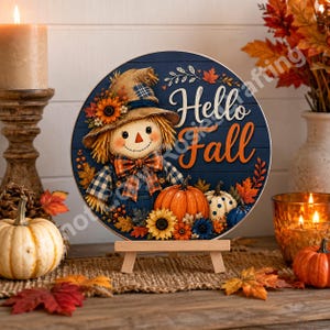 Rustic autumn wall art showing smiling scarecrow, pumpkin patch accents, sunflowers, and fall foliage.