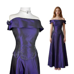 May include: A floor-length, off-the-shoulder dress in a deep iridescent purple fabric. The bodice features a wide folded neckline, small fabric rosettes on the sleeves, and a curved waist panel adorned with intricate dark beadwork and embroidery.