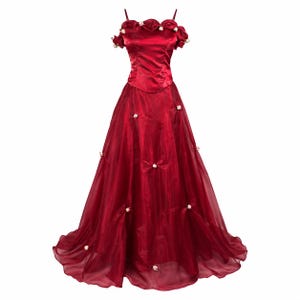 Könnte beinhalten: Ein bodenlanges, dunkelrotes Kleid mit einem Satin-Oberteil, dünnen Trägern und einem schulterfreien, gerüschten Ausschnitt. Der Rock besteht aus einem transparenten, mehrlagigen Stoff, der mit kleinen, weißen Blütenakzenten verziert ist.