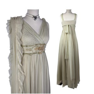 Puede incluir: Dos elegantes vestidos verde claro sobre maniquíes. Uno presenta un escote en V, un corpiño de encaje y una cintura adornada. El otro tiene un escote cuadrado y una falda fluida. Ambos vestidos son largos y adecuados para ocasiones formales.