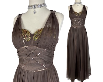 May include: A brown evening gown with a flowing skirt and halter neckline. The bodice features intricate sequin and embroidered detailing in gold and green. A matching rhinestone choker necklace is included.