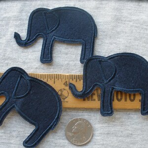May include: Three dark blue felt elephant appliques. The elephants are all the same size and shape, with a simple design.