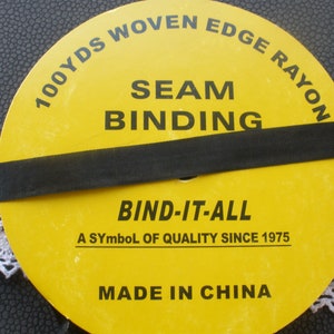 May include: A yellow spool of 100 yards of woven edge rayon seam binding. The spool is labeled "Bind-It-All, A Symbol of Quality Since 1975, Made in China".