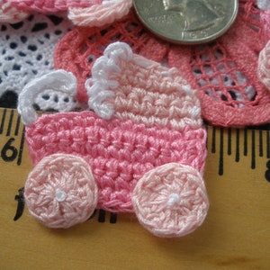 May include: Pink crocheted baby carriage applique with white trim and pink wheels. The applique is about 2 inches wide and 2 inches tall.