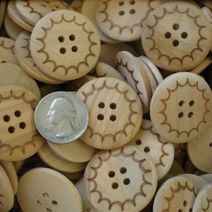 May include: A pile of wooden buttons with a scalloped edge and four holes. The buttons are a light brown color and are arranged in a random pattern.