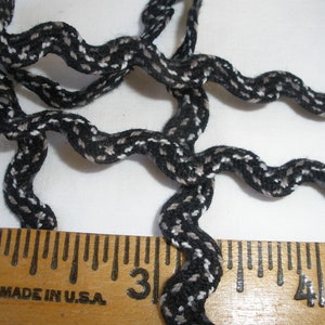May include: Black and white wavy trim with a ruler showing 2 inches, 3 inches, and 4 inches.