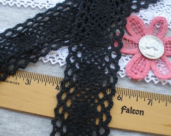 May include: Black crochet lace trim with a scalloped edge. The lace is approximately 2 inches wide and is shown next to a ruler.