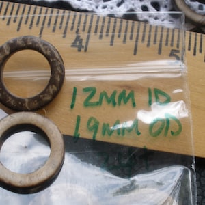 May include: Two brown and white rings with a ruler in the background. The rings are 12mm ID and 19mm OD.