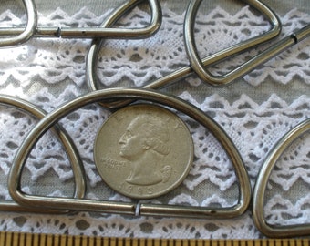 May include: A close-up of a silver metal D-ring, with a US quarter for scale. The D-ring is about 2 inches in diameter.