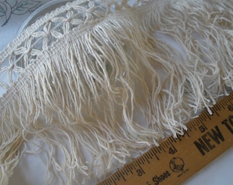 Puede incluir: Borde de flecos de algodón blanco con un delicado patrón de ganchillo. Los flecos tienen aproximadamente 2,5 cm de largo.