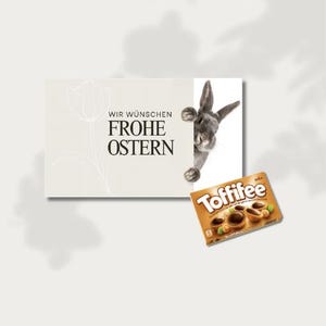 May include: A greeting card with the text "WIR WÜNSCHEN FROHE OSTERN" and a tulip illustration, accompanied by a gray rabbit peeking from behind. A box of Toffifee chocolates is also present.
