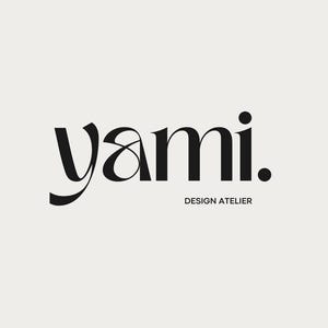 May include: A minimalist logo design featuring the word "yami." in a bold, elegant black font. Below the word is the text "DESIGN ATELIER" in a smaller, sans-serif font, also in black, set against a cream background.