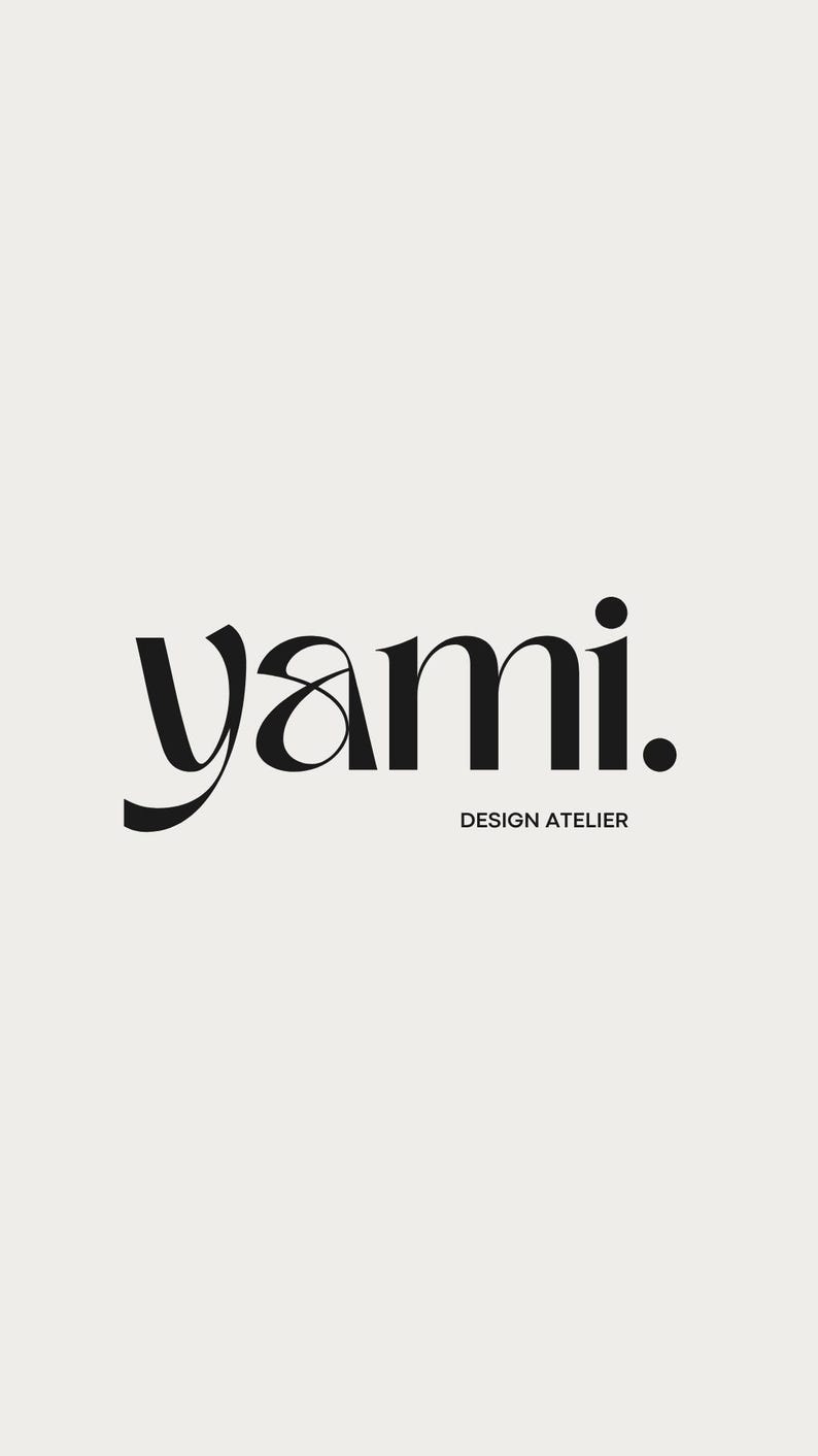 May include: A minimalist logo design featuring the word "yami." in a bold, elegant black font. Below the word is the text "DESIGN ATELIER" in a smaller, sans-serif font, also in black, set against a cream background.