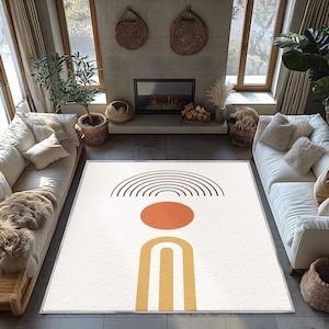 May include: A cream-colored area rug with a geometric design featuring a brown arched pattern, an orange circle, and a yellow arch. The rug is in a living room setting with white sofas, plants, and a fireplace.