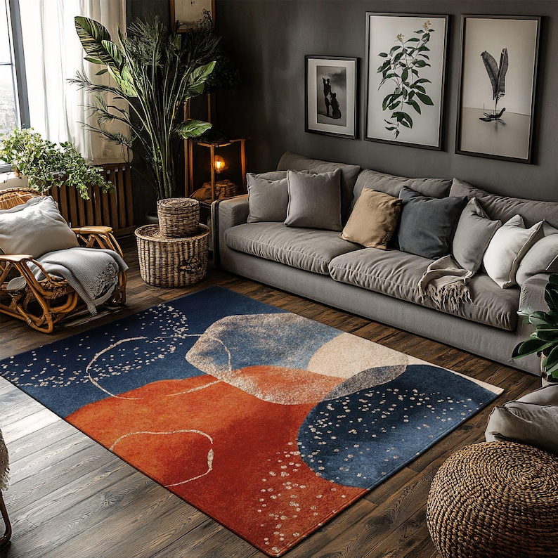 May include: A modern area rug with an abstract design in shades of blue, orange, and cream. The rug features a pattern of overlapping shapes and scattered white dots, adding a contemporary touch to the living room setting.