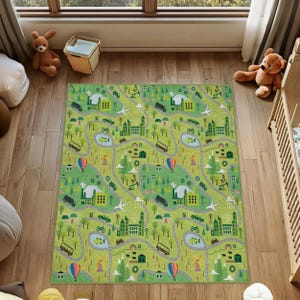 Peut inclure: Un tapis rectangulaire au fond vert clair orné d'un motif répétitif de routes grises sinueuses, d'usines, de maisons, d'arbres, de montgolfières, d'avions et de divers véhicules, notamment des camions, des bus et des voitures.