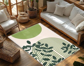 May include: A rectangular area rug featuring a cream-colored background with a large sage green semi-circle at the top and a series of dark green concentric arched lines layered with dark green leaf silhouettes across the bottom.