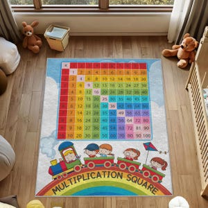 Könnte beinhalten: Bunter Kinderteppich mit einem Einmaleins-Quadrat. Das Design zeigt ein Raster mit Zahlen, einen Zug mit Kindern und den Schriftzug "MULTIPLICATION SQUARE" über einem Regenbogen.