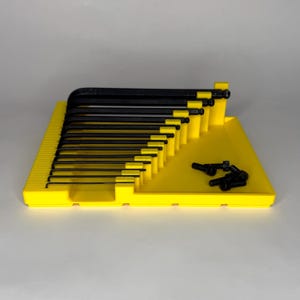 Front view of a yellow 3D-printed Bondhus inch Allen wrench organizer tray containing 13 black hex keys. The tray features a built-in magnetic parts area on the right with several black socket head screws. Each wrench slot is labeled with embossed inch sizes from .05" to 3/8".