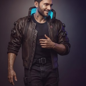 Puede incluir: Chaqueta de cuero marrón con detalles de neón azul en el cuello. La chaqueta se lleva sobre una camiseta negra. El texto "The Darkline Apparel" está en la parte inferior de la imagen.